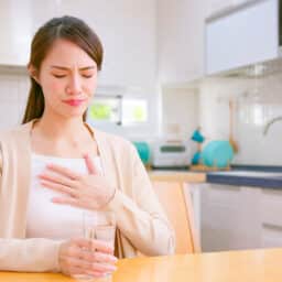 Young woman experiencing acid reflux.