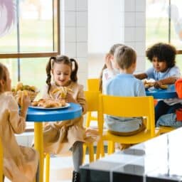 Group of young children eating lunch at school.