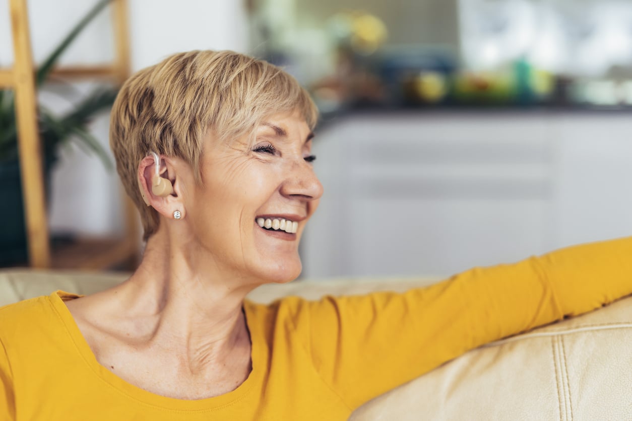 Woman with hearing aid smiles