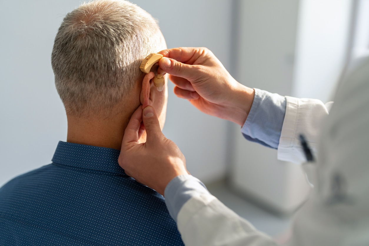 Senior man getting a new hearing aid.