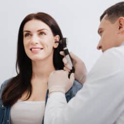 ENT conducting an ear exam on a young woman