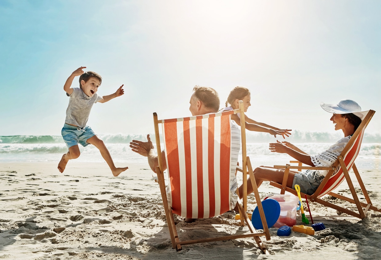 Beach, sunshine and family with vacation, happiness and excited with getaway trip, chairs and playful.
