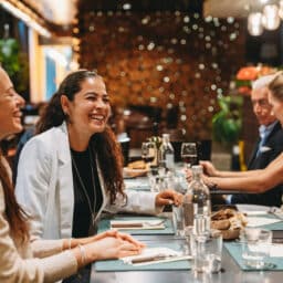 Smiling group of friends laughing at lunch.