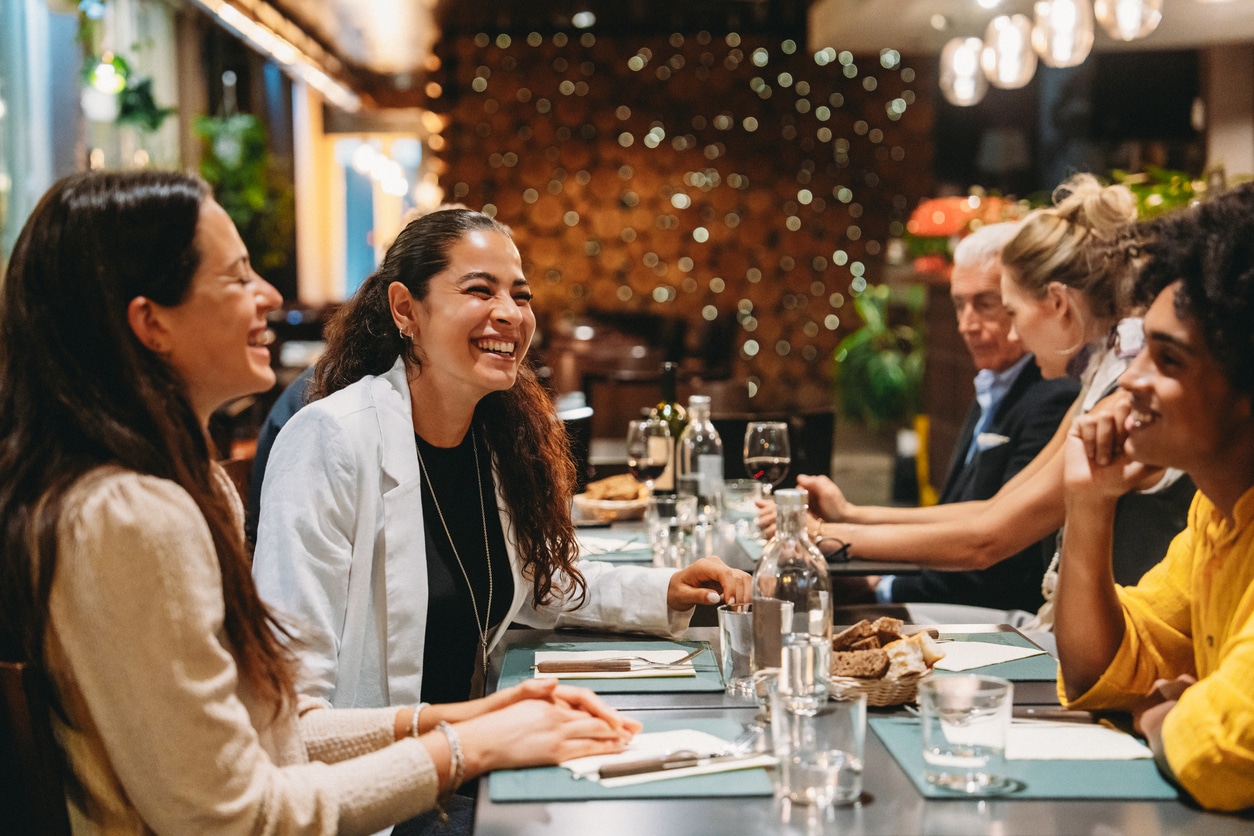 Smiling group of friends laughing at lunch.