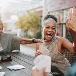 Senior friends smiling and playing cards.